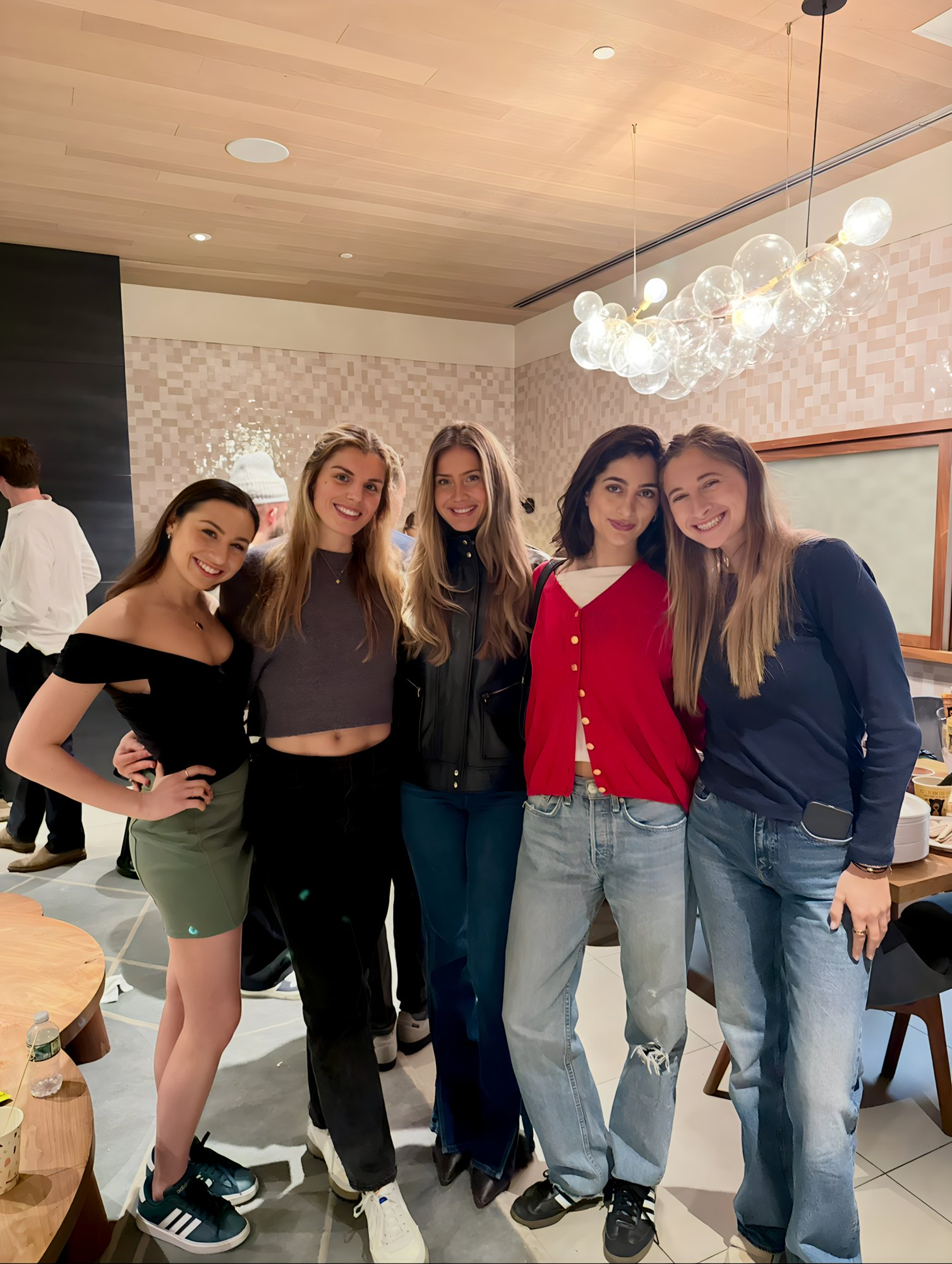 Five guests posing together under the bubble chandelier at The Healthiest Desserts