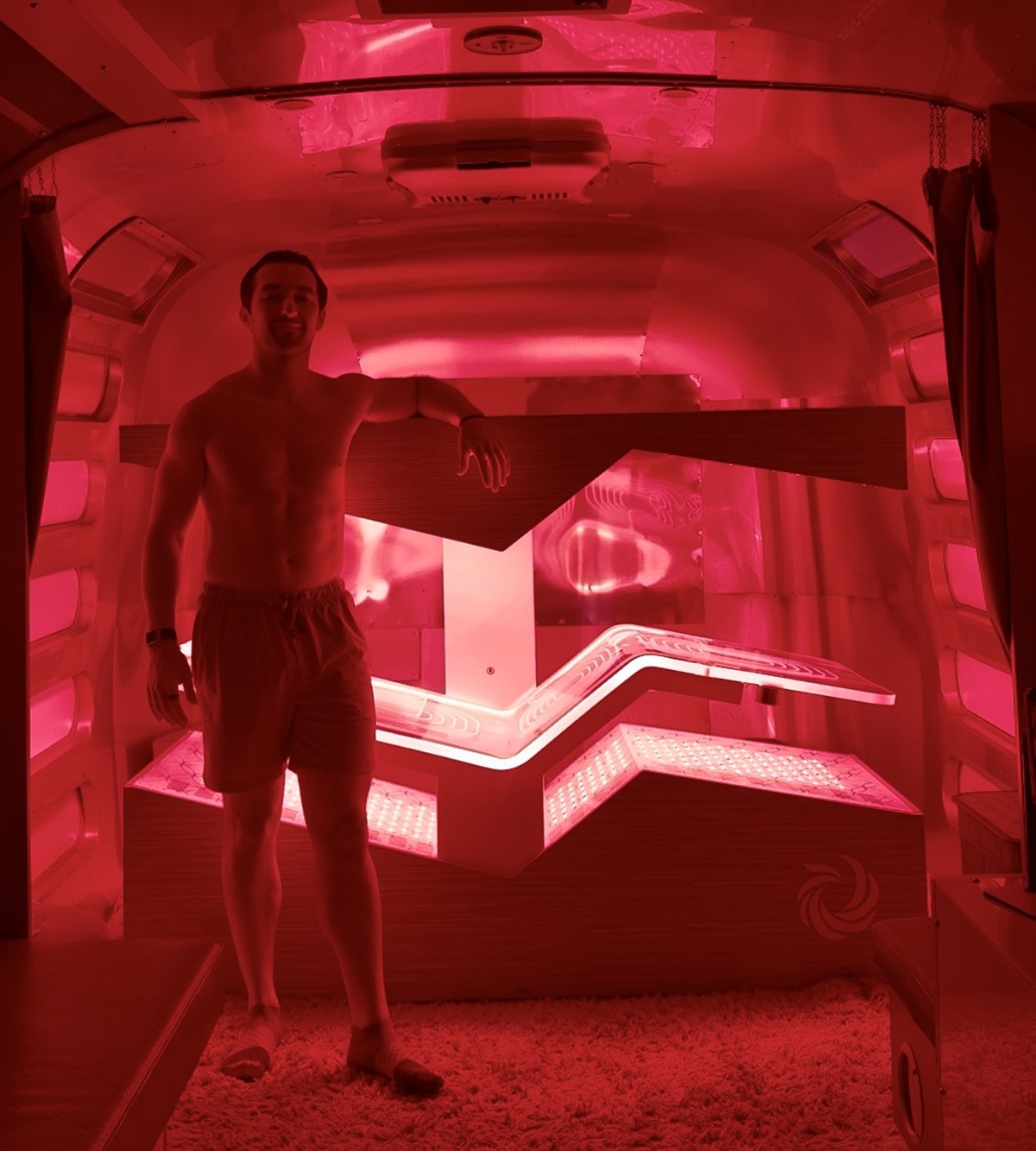 Adam inside a red-light therapy health tech cabin