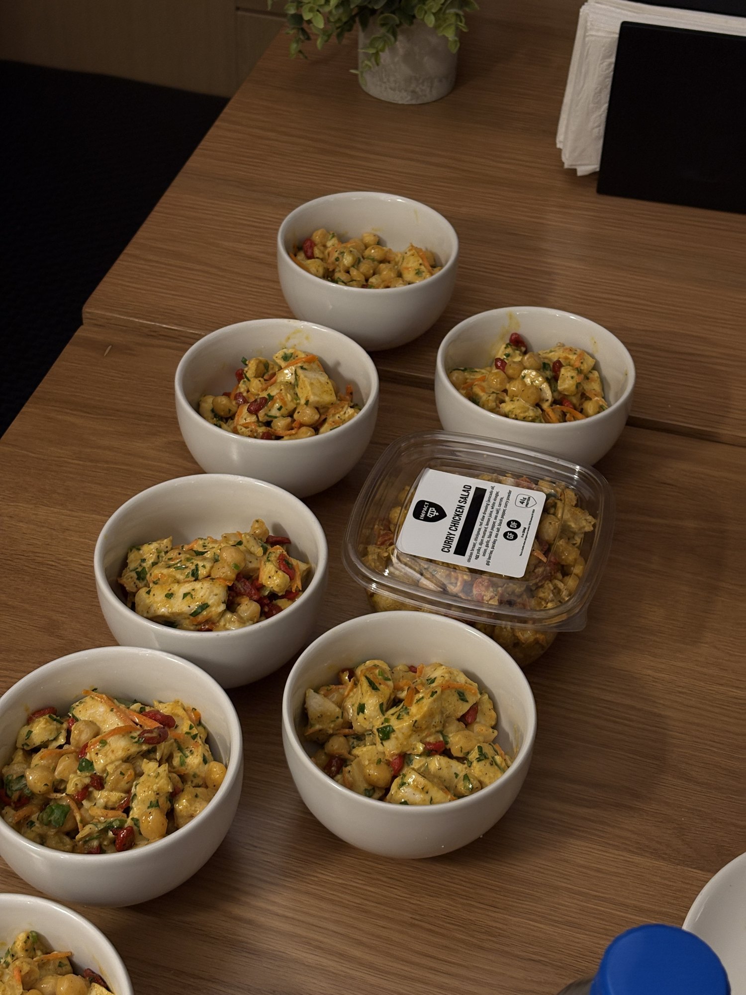 Bowls of curry chicken salad on a wood table at a stop on the Healthy Food Crawl