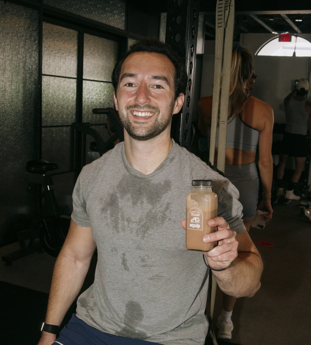Adam holding an Equip protein shake after a workout