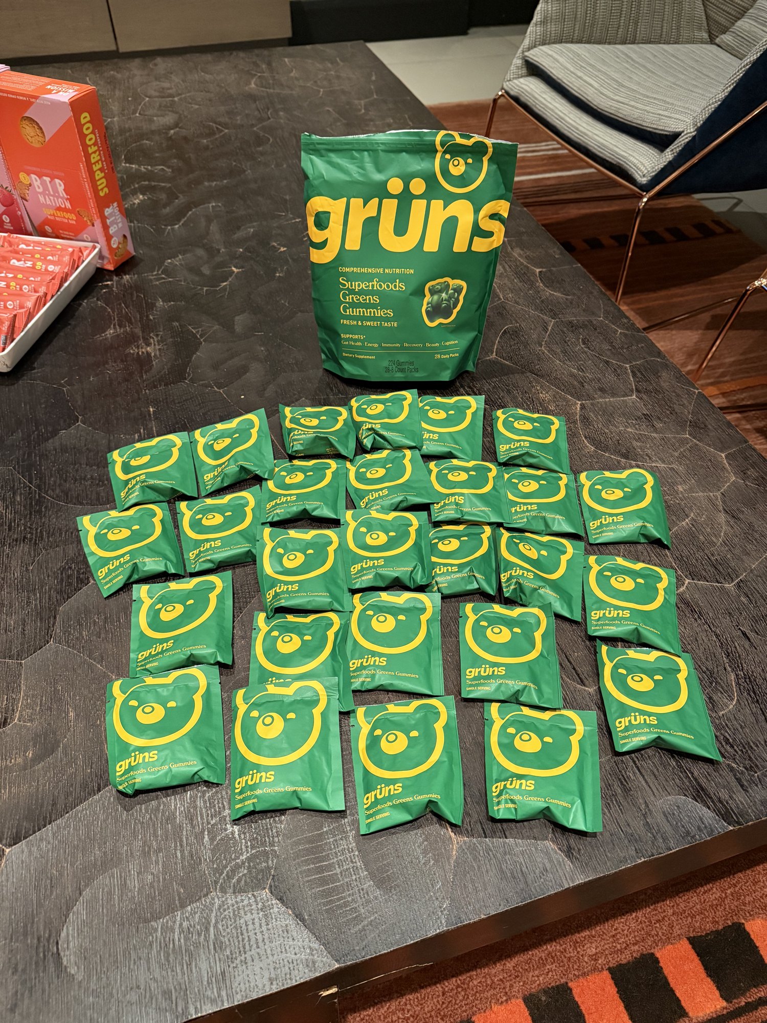 Green Gruns superfood gummies packets arranged on a table at an NYC Health Collective event